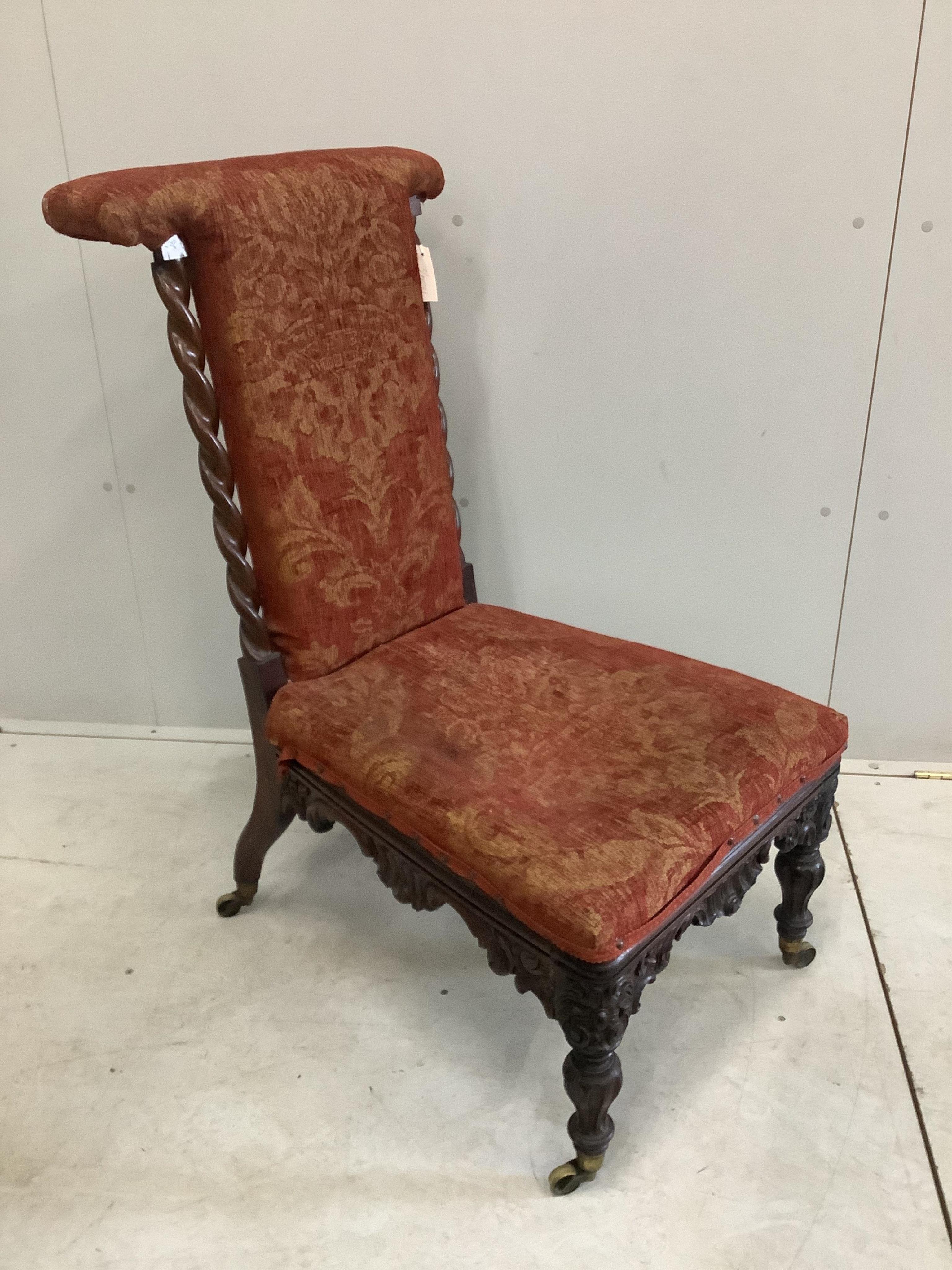 A Victorian carved rosewood prie dieu chair with later upholstery. Condition - fair